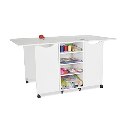 Foldable white craft table with storage shelves and wheels