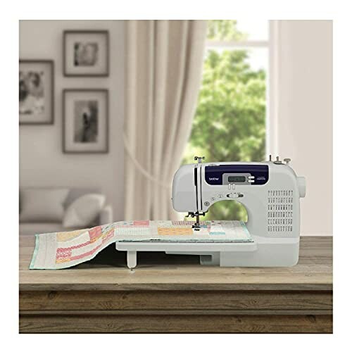 Sewing machine on a wooden table with quilt in a cozy room.