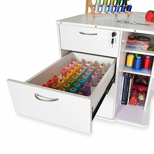 Open sewing cabinet drawer filled with colorful thread spools.