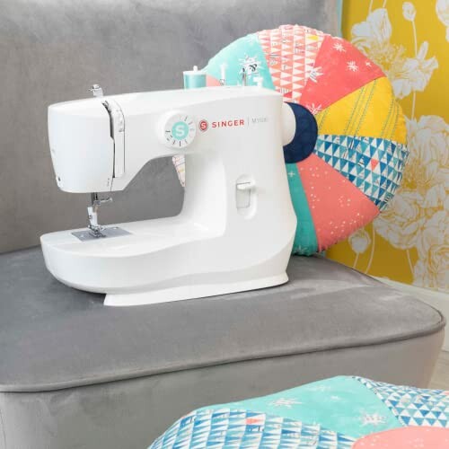 Singer sewing machine on a couch with colorful pillows