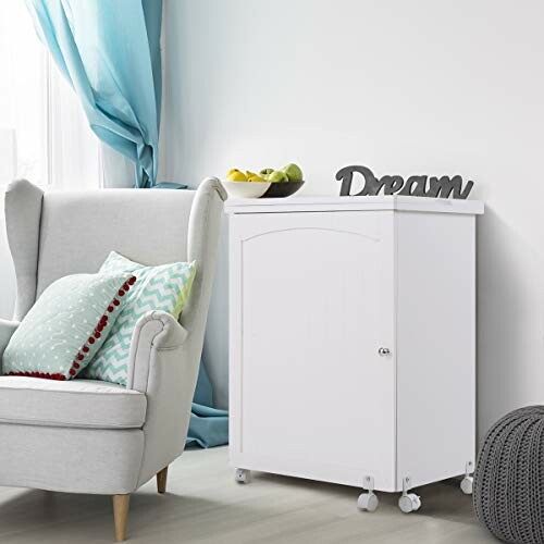 White cabinet on wheels in a living room with an armchair and decor.